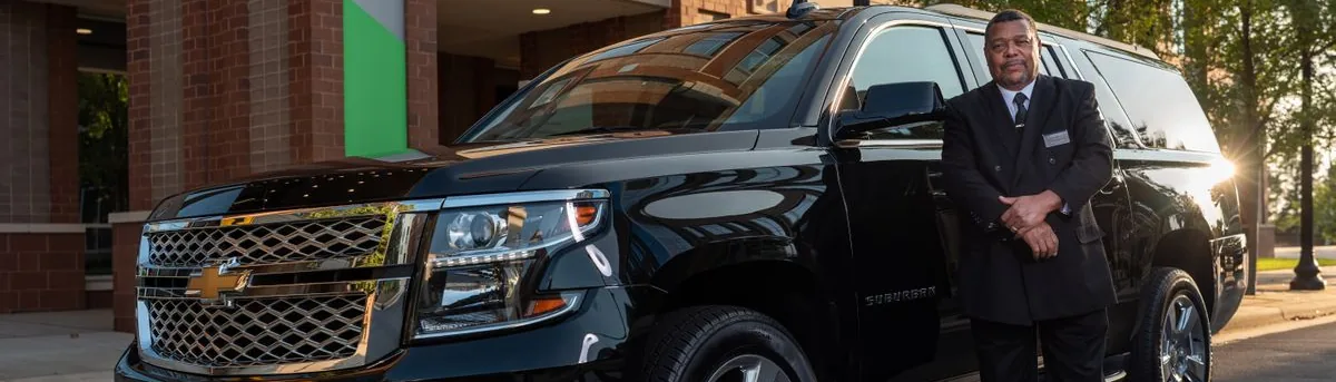 Chauffeur standing by the transfer SUV