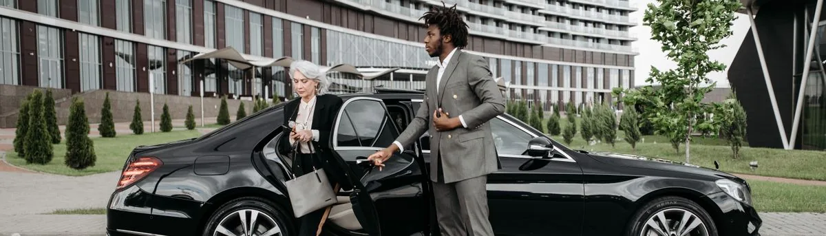 Driver helping a passenger out of the car