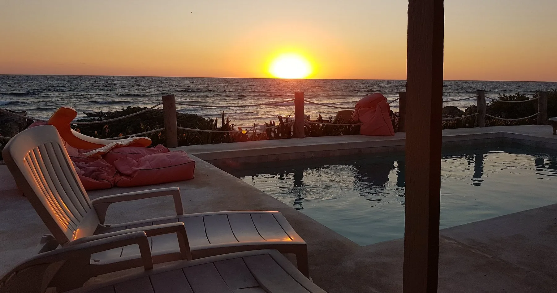 The sun over the sea by the pool and bean bags at Punta Piedra Studios