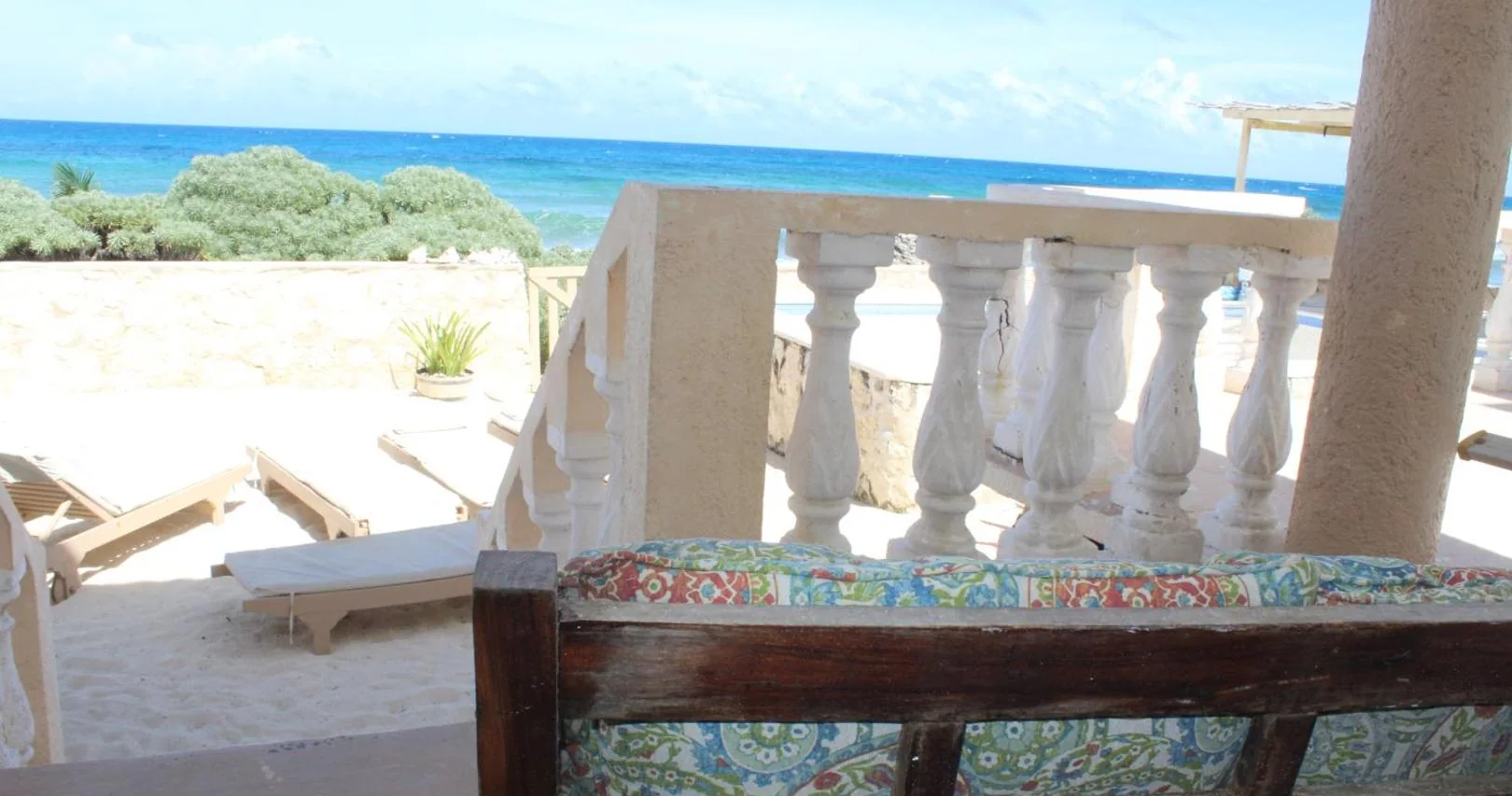 White balustraded terrace with loungers and the turquoise sea